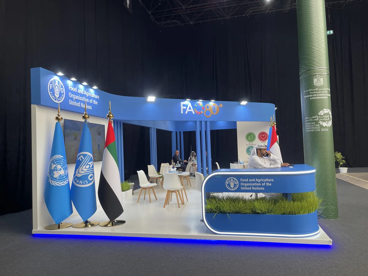 FAO exhibition stand at the Emirates Agriculture Conference 2026, ADNEC Al Ain — UN, FAO and UAE flag display with branded reception desk